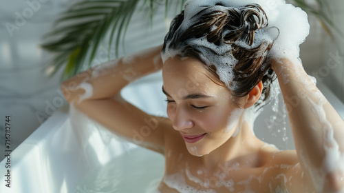 Woman washes hair and enjoys bathing photo