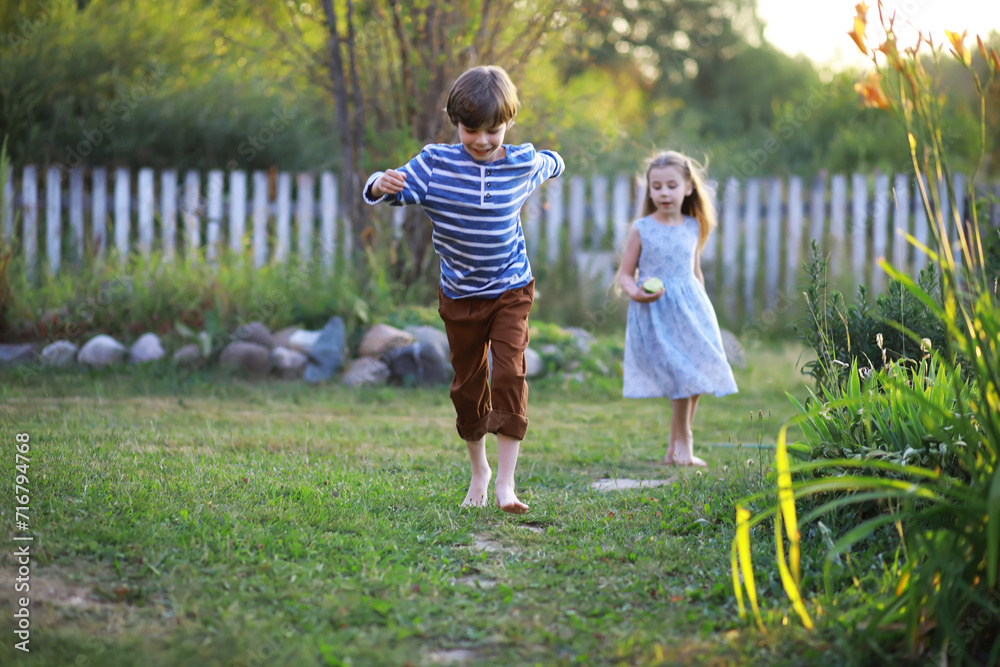 Fototapeta premium Children walk in the summer in nature. Child on a sunny spring morning in the park. Traveling with children.