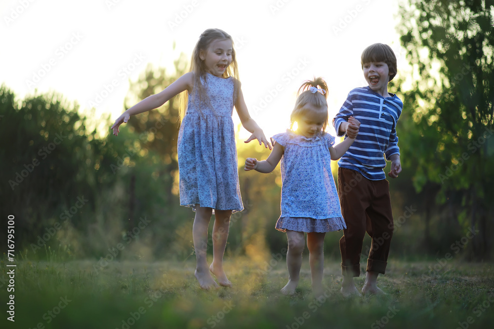 Fototapeta premium Children walk in the summer in nature. Child on a sunny spring morning in the park. Traveling with children.