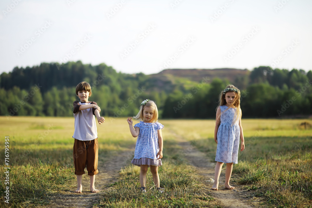 Fototapeta premium Children walk in the summer in nature. Child on a sunny spring morning in the park. Traveling with children.