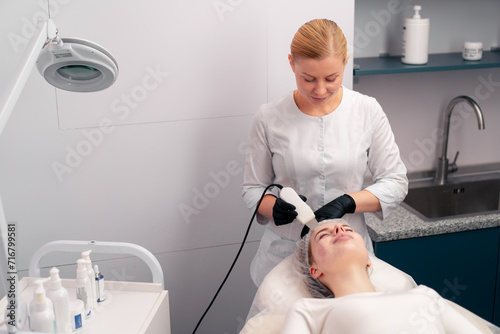 Bild auf Leinwand a cosmetologist will perform a face-lifting cosmetic procedure on a client in a