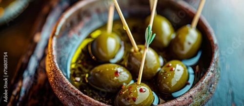 A vibrant array of plump, golden olives, adorned with toothpicks, invite you to savor the natural beauty and delicious taste of this mediterranean vegetable dish photo