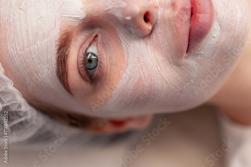 close-up of a girl's face with a cream or mask during a cosmetic procedure in a beauty salon
