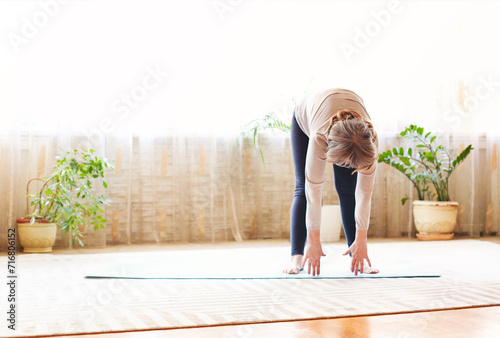 Mature woman stretching body on floor