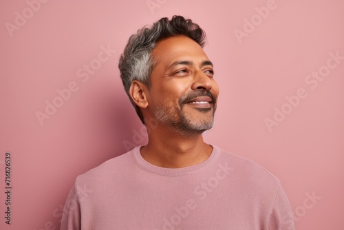 Portrait of a blissful indian man in his 40s wearing a thermal fleece pullover against a pastel or soft colors background. AI Generation
