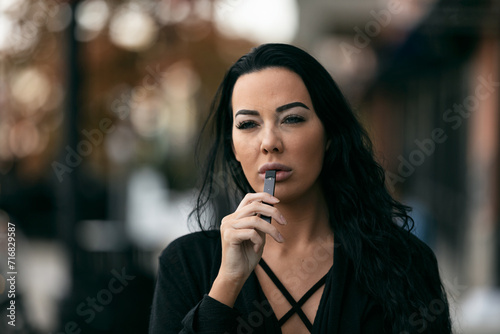 Adult Female Vaping With An E-Cigarette photo