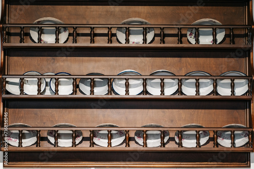 antique tableware at home in Istanbul. an open cupboard for dining utensils in the kitchen in Turkey. the texture of the shelves with plates photo