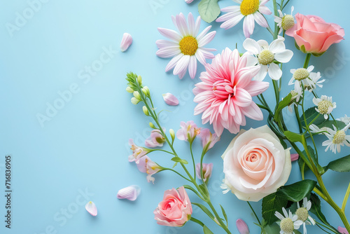 Bouquet of beautiful spring flowers on pastel blue table top view