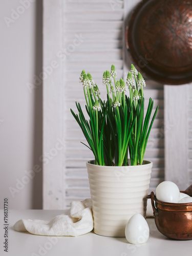 White Muscari flowers and white eggs in a rustic bowl. Rustic mood Easter decor