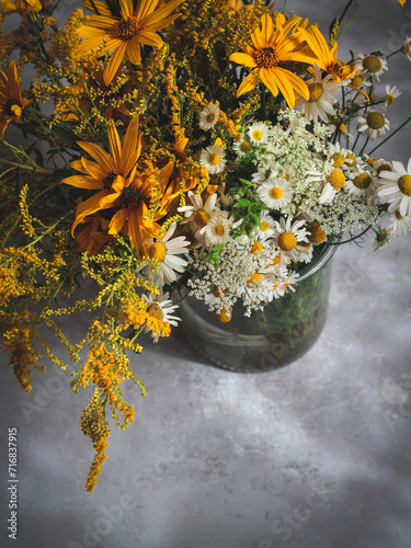 A bouquet of wild flowers in a glass vase with a copy space, shot from above