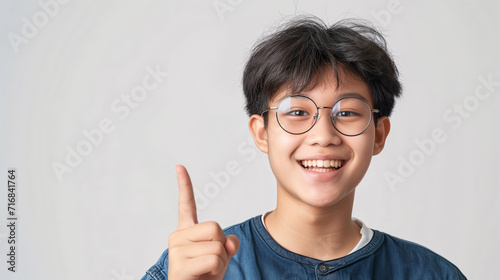 boy pointing finger towards empty space for editing isolated on light background