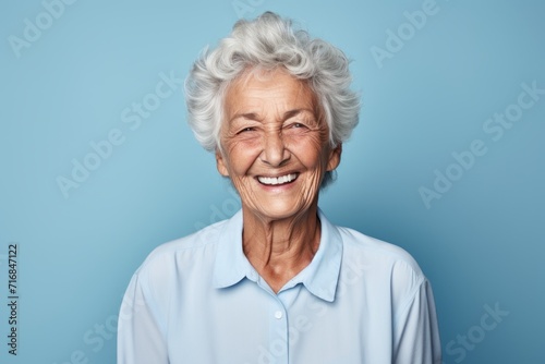Portrait of a cheerful elderly woman in her 90s wearing a simple cotton shirt against a solid color backdrop. AI Generation