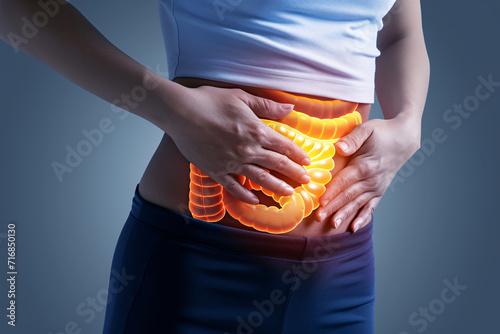 Gastrointestinal complaints concept, a woman holding her stomach, hologram intestines depicting abdominal pain or discomfort