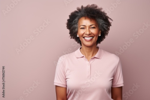 Portrait of a grinning afro-american woman in her 60s wearing a sporty polo shirt against a light wood minimalistic setup. AI Generation