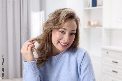 Portrait of smiling woman with curly hair at home