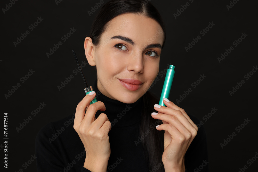 Obraz premium Beautiful young woman with mascara on black background