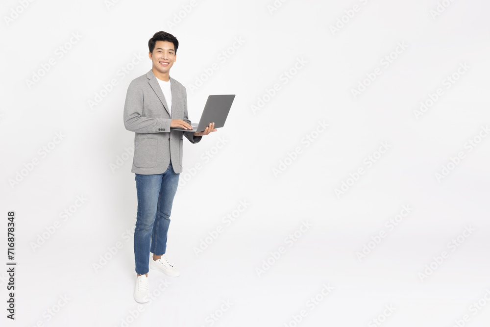 Happy young Asian businessman using laptop computer isolated on white background