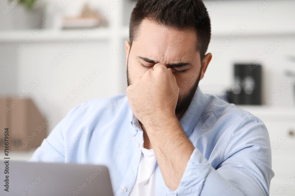 Man suffering from headache at workplace in office Man suffering from headache at workplace in office