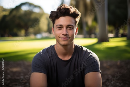 Portrait of a relaxed boy in his 20s practicing yoga in a park. With generative AI technology