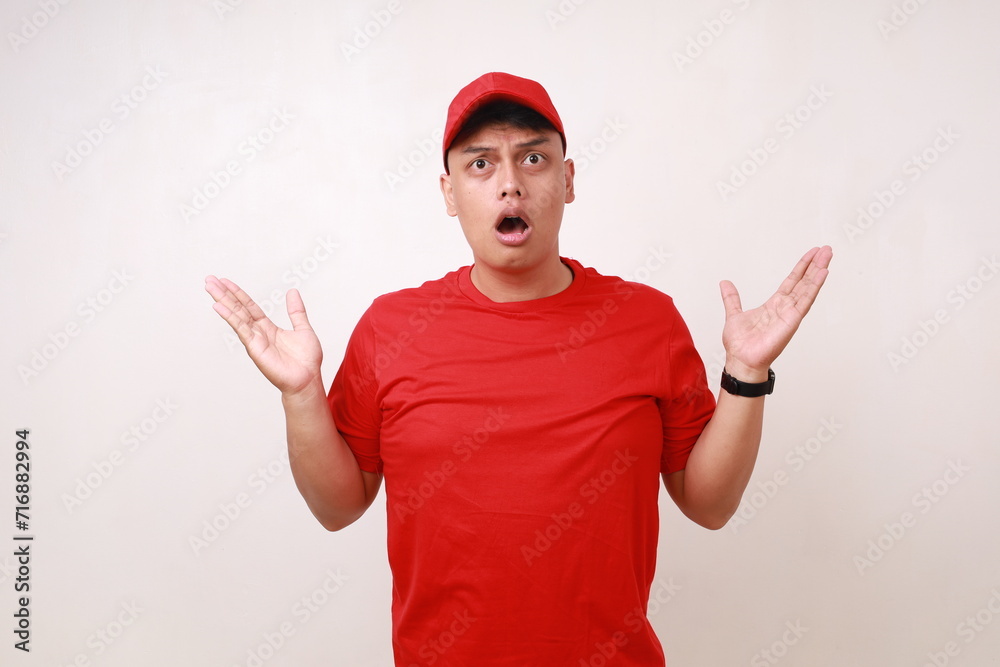 Confused Handsome young asian courier standing with question hand gesture and expression against white background Confused Handsome young asian courier standing with question hand gesture and expression against white background