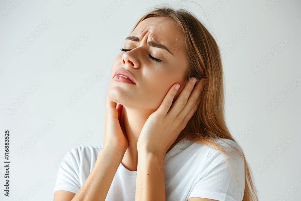 Frustrated female feeling neck discomfort, white backdrop Frustrated female feeling neck discomfort, white backdrop