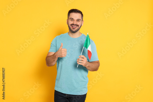 Man with flag of Italy showing thumb up on yellow background