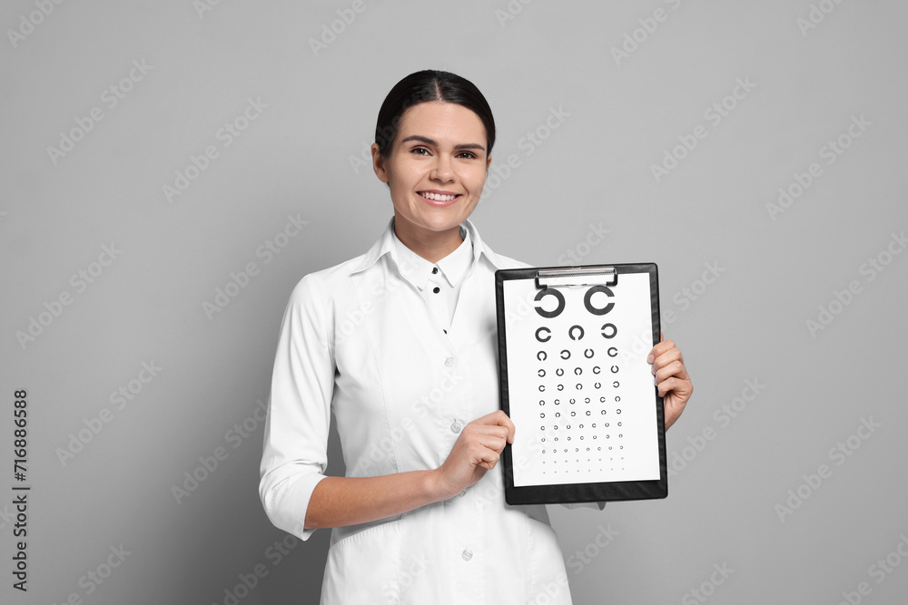 Ophthalmologist with vision test chart on gray background Ophthalmologist with vision test chart on gray background