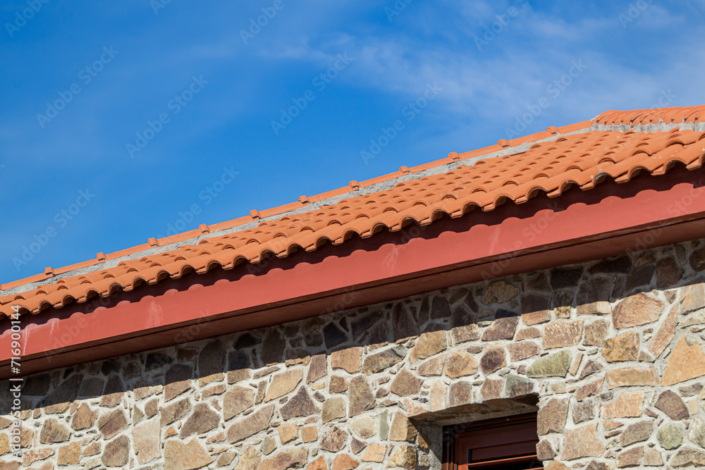 New clay tile roof on renovated antique stone house. Restoration of old buildings
