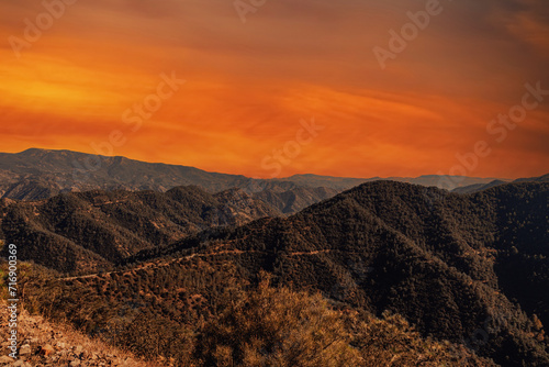 Mountain landscape at sunset. A view of the mountains with a bright orange sky in the background