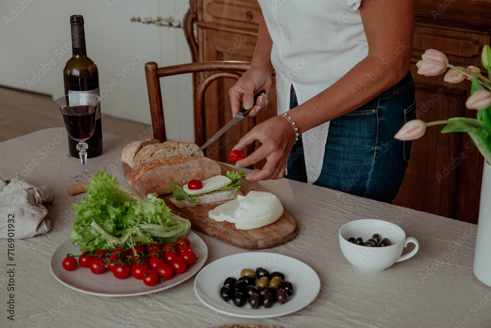Close-up of hands preparing snack sandwich and wine in kitchen Close-up of hands preparing snack sandwich and wine in kitchen