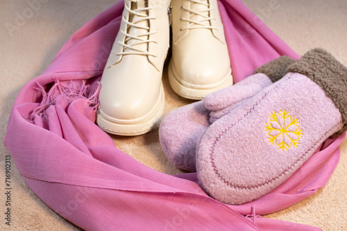 Beige winter women's leather boots and Cute pink mittens with pink Scarf. Beautiful modern Clothes for cold weather wearing. Romantic Present for girl on Saint Valentine day.