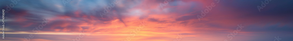 Vibrant extra wide panoramic sky. Fantasy banner sky. Rich colors. Daytime sunset beauty. Fiery glowing heavenly sky with gradient colors. Red, pink, orange, blue, yellow. Dark stormy clouds