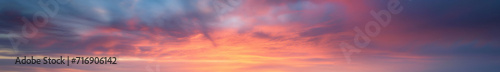 Vibrant extra wide panoramic sky. Fantasy banner sky. Rich colors. Daytime sunset beauty. Fiery glowing heavenly sky with gradient colors. Red, pink, orange, blue, yellow. Dark stormy clouds