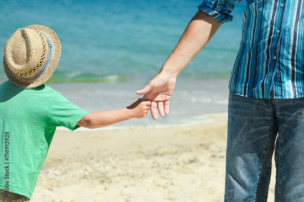 A Hands of a happy parent and child on the seashore on a journey trip in nature A Hands of a happy parent and child on the seashore on a journey trip in nature