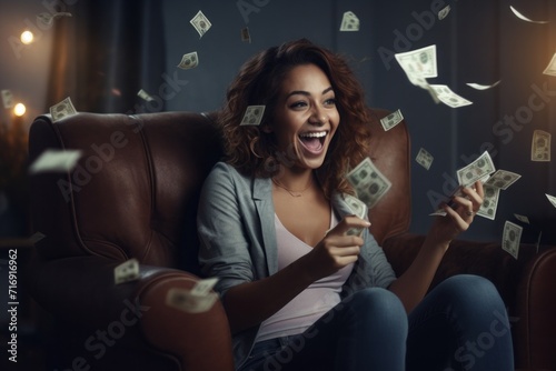 Portrait of a happy woman holding money in her hands and sitting in an armchair. photo