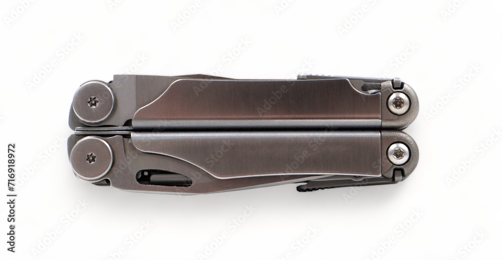 Folded steel multitool isolated on white background, top view. A tool for daily practice. All in one. Construction and repair. Compact and portable product. Pocket knife. EDC concept. Folded steel multitool isolated on white background, top view. A tool for daily practice. All in one. Construction and repair. Compact and portable product. Pocket knife. EDC concept.