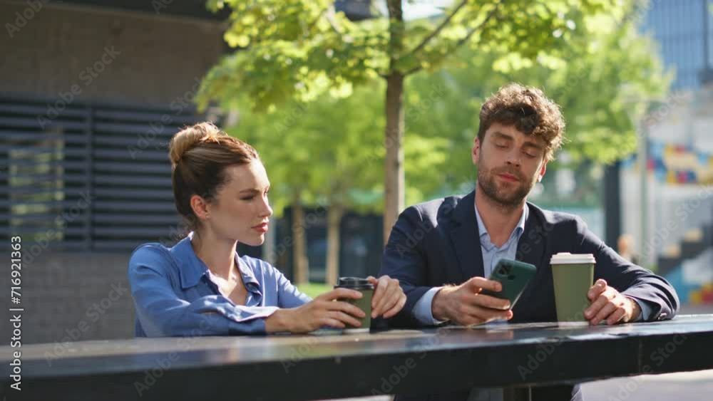 Corporate couple enjoying break on street. Business partners drinking coffee Corporate couple enjoying break on street. Business partners drinking coffee