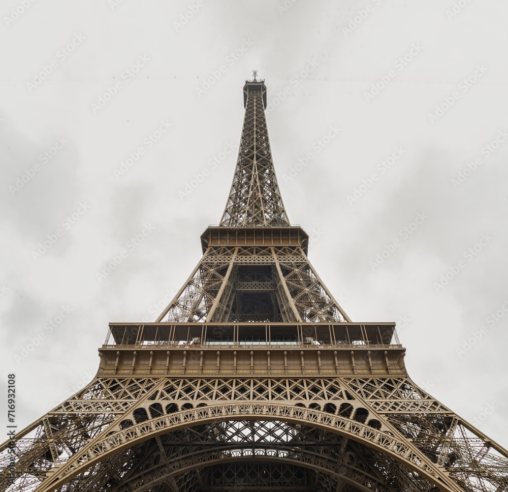 Low angle shot of Famous Eiffel tower iron structure with white sky background. Architectural detail design of the Eiffel tower in Paris. Paris Best Destinations in Europe.
