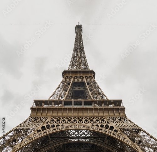 Low angle shot of Famous Eiffel tower iron structure with white sky background. Architectural detail design of the Eiffel tower in Paris. Paris Best Destinations in Europe.