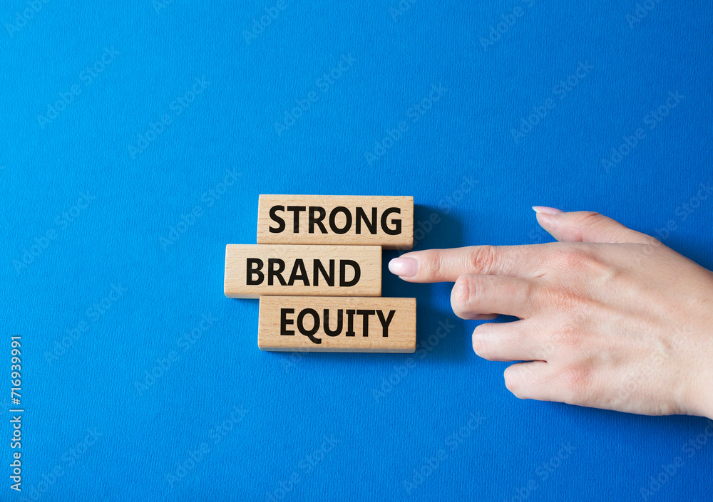 Strong Brand Equity symbol. Concept words Strong Brand Equity on wooden blocks. Businessman hand. Beautiful blue background. Business and Strong Brand Equity concept. Copy space Strong Brand Equity symbol. Concept words Strong Brand Equity on wooden blocks. Businessman hand. Beautiful blue background. Business and Strong Brand Equity concept. Copy space