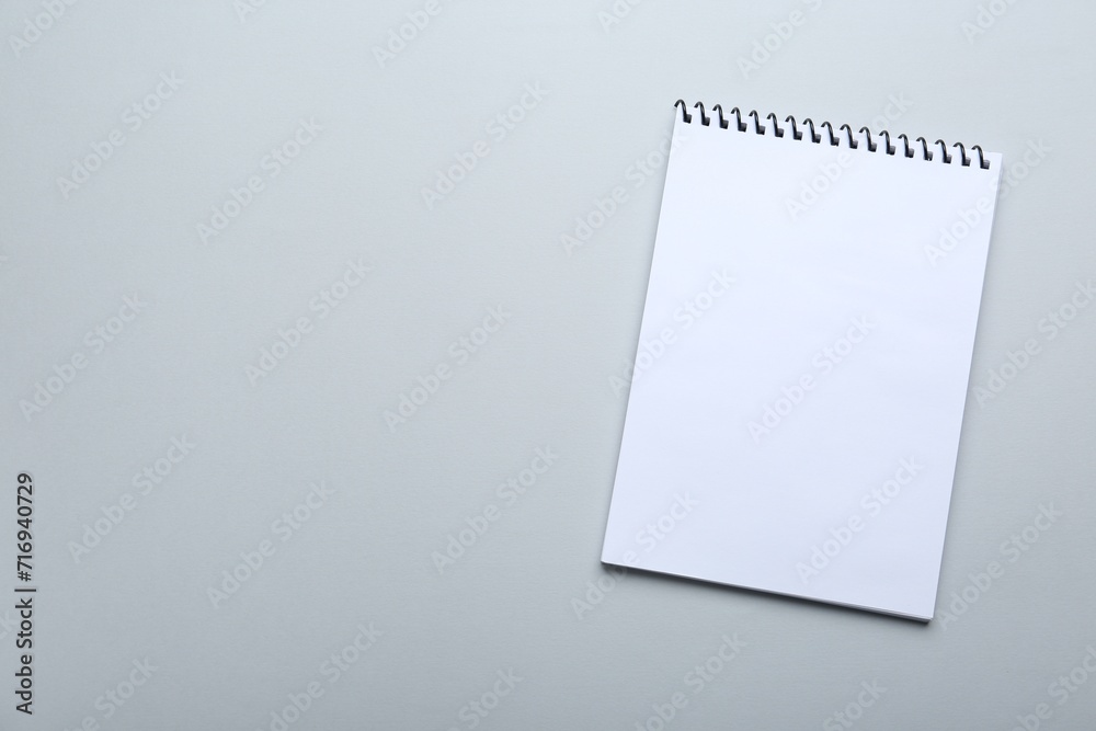 One notebook on light grey background, top view. Space for text