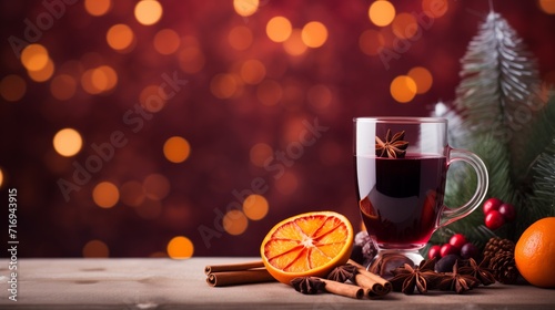 Warm mulled wine with spices, orange slice, and festive holiday blurred backdrop