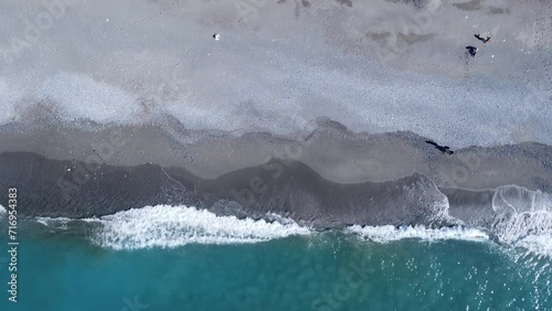 Foto dall'alto delle onde che si infrangono sulla spiaggia costiera. Surf sulla spiaggia tropicale. Vista aerea astratta sull'oceano photo