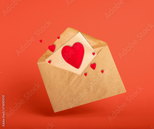 Vintage envolope and red hearts on red background. © dvulikaia