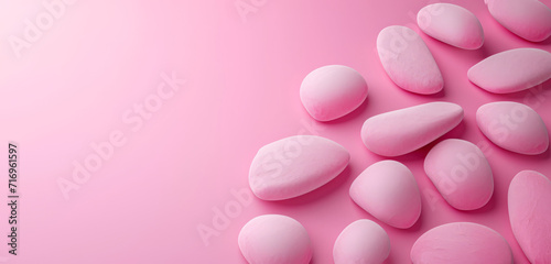 Assorted pebbles lined up against a colourful pink gradient background, peaceful and calming.