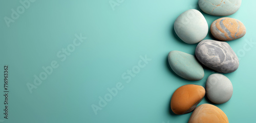 Assorted pebbles lined up against a light blue gradient background  peaceful and calming.