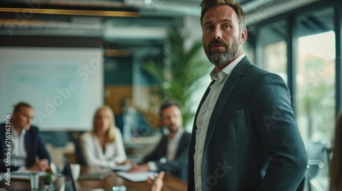 Group of diverse businesspeople discussing paperwork together during a meeting around a table in a modern office