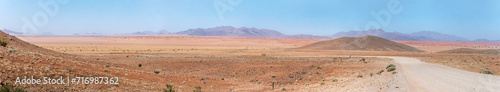 gravel road bending in colorful countryside of Naukluft desert, west of Betta, Namibia