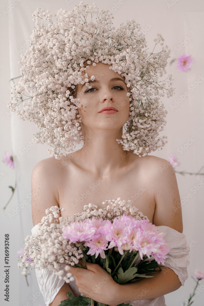 Portrait of sensual blond woman with flowers. Beautiful girl with flowers in her hair. Summer Beauty. Art in a contemporary style. A gypsophila wreath on a white background. Perfume, cosmetics concept Portrait of sensual blond woman with flowers. Beautiful girl with flowers in her hair. Summer Beauty. Art in a contemporary style. A gypsophila wreath on a white background. Perfume, cosmetics concept