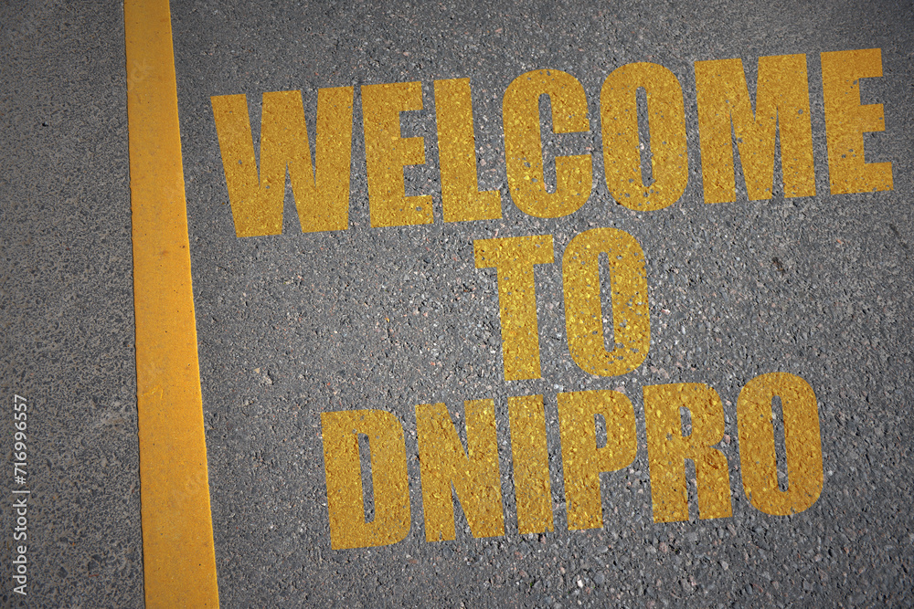 asphalt road with text welcome to Dnipro near yellow line.